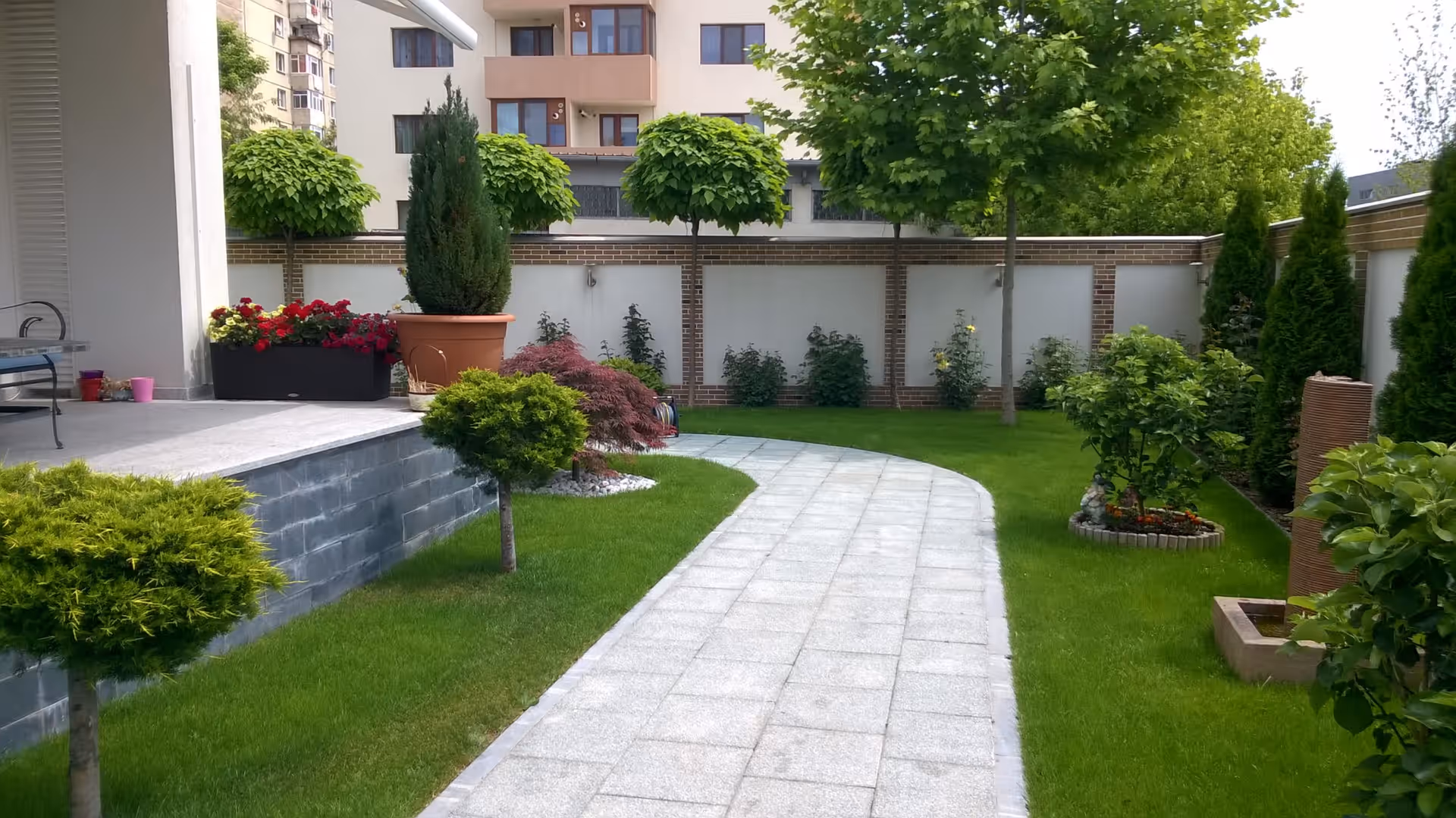 Alee de piatră printr-o grădină amenajată de Sara's Gardens